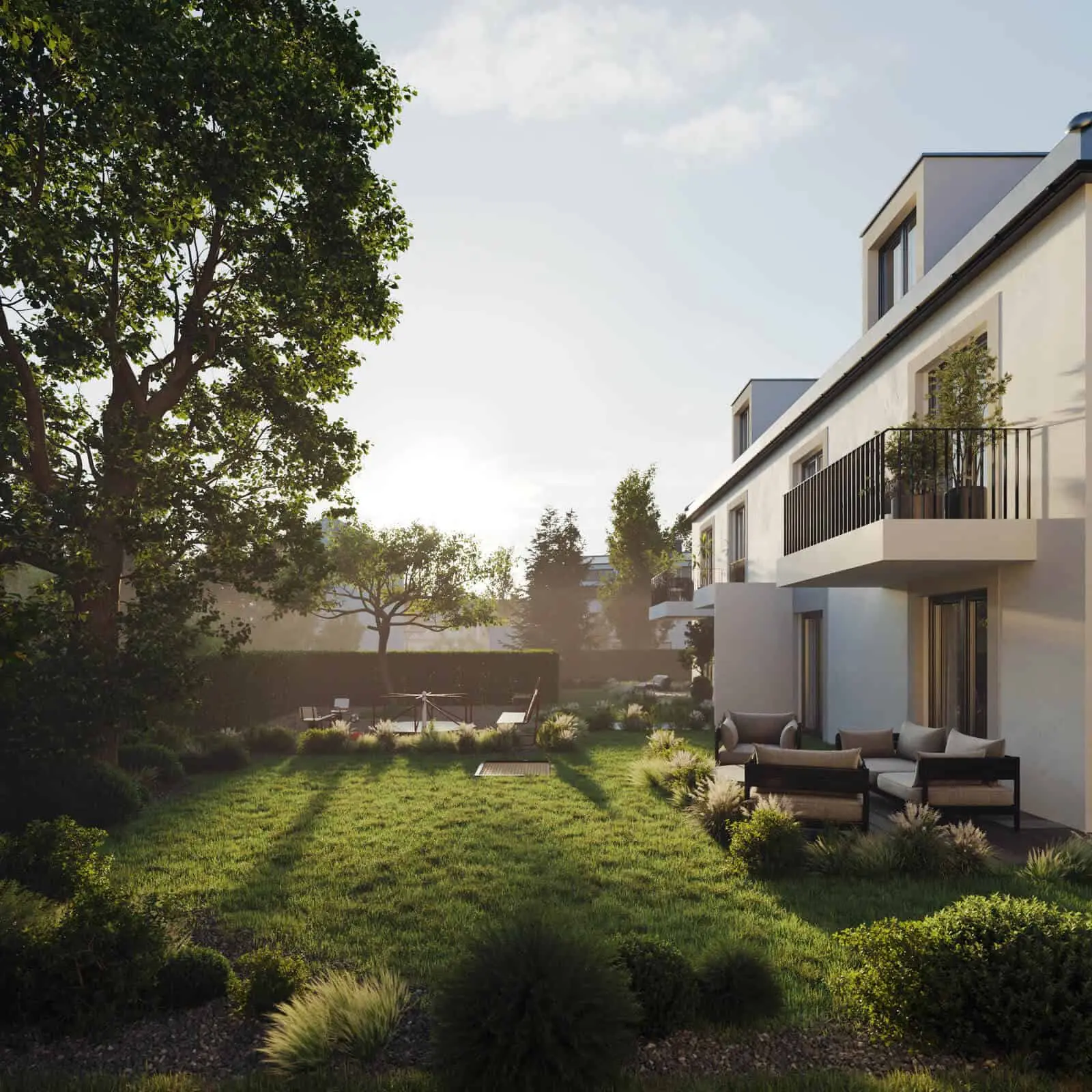 Modern two-story house with balconies and outdoor seating, surrounded by a landscaped green lawn and trees, under a clear sky at sunset.