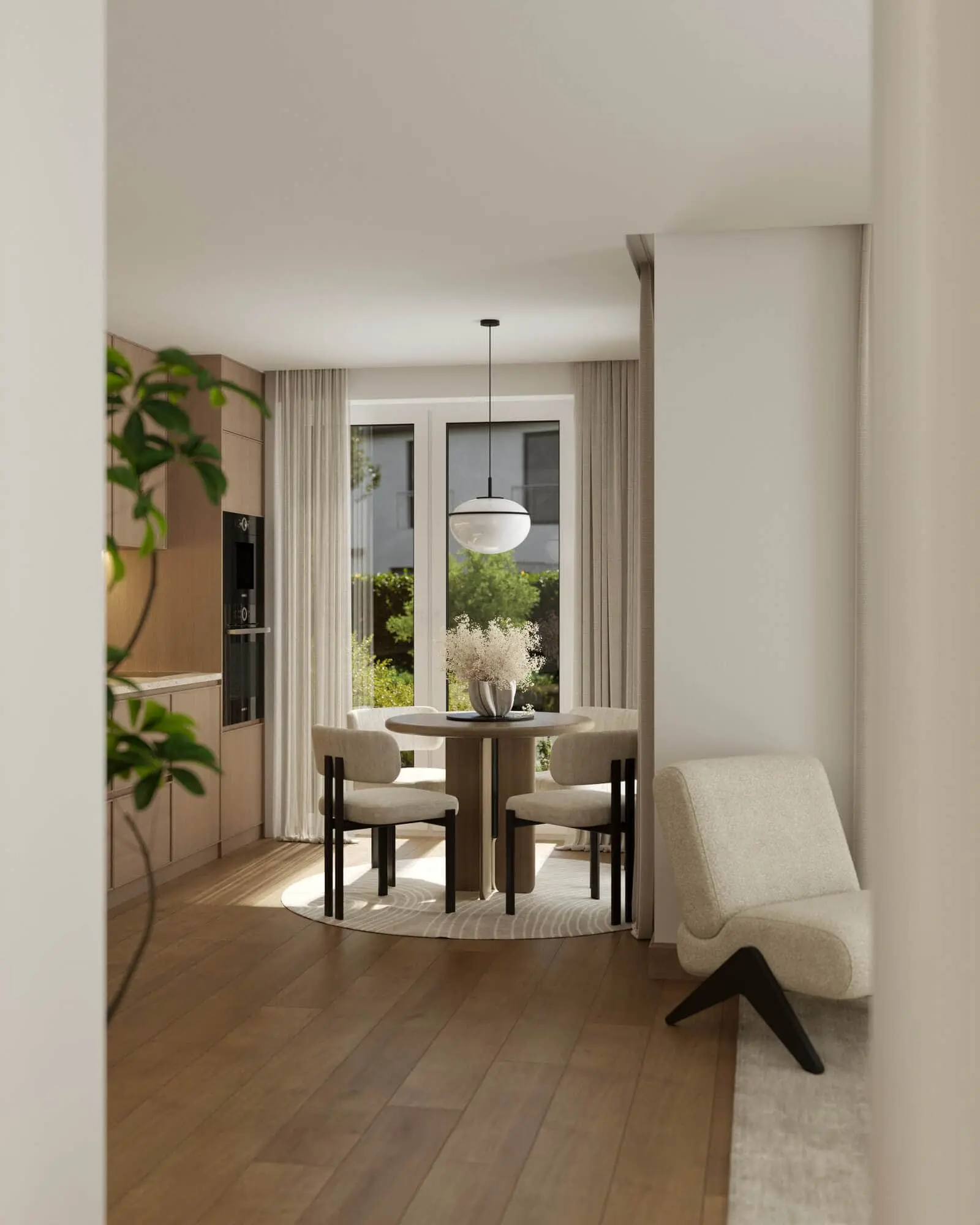 A modern dining area with a round table, four chairs, and a pendant light near large windows overlooking greenery; a lounge chair sits in the foreground.